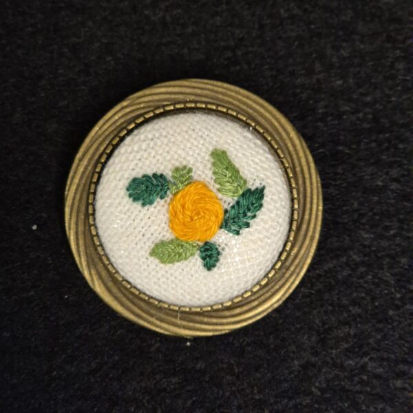 Broche style vintage avec une décoration brodée d'une fleur orange