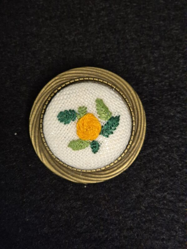 Broche style vintage avec une décoration brodée d'une fleur orange